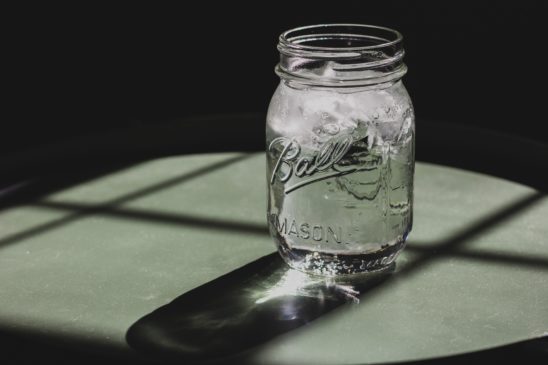 Wasserglas auf Tisch in der Sonne