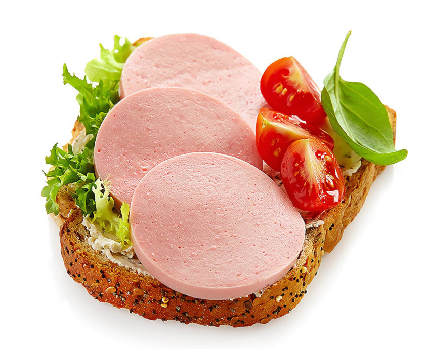 Brot mit Fleischwurst, Salat, Tomate und Basilikum zur Veranschaulichung von modernem verarbeitetem Essen.