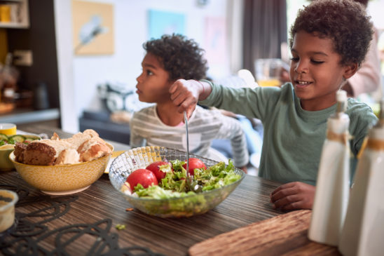 Kleine Kinder die intuitiv Salat und Gemüse essen und schlank sind.